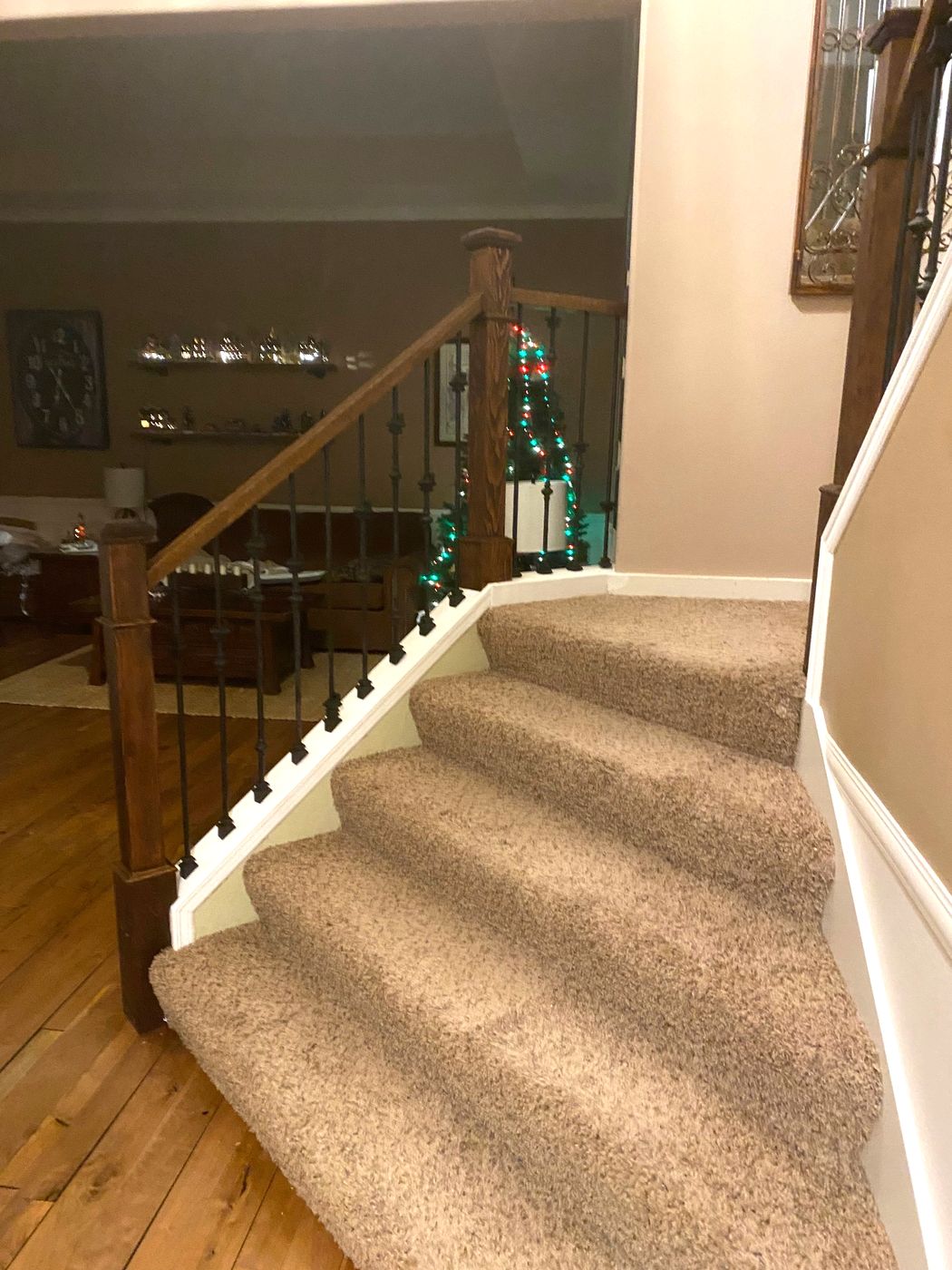 Carpeted winder stairs with iron balusters and wood newel posts