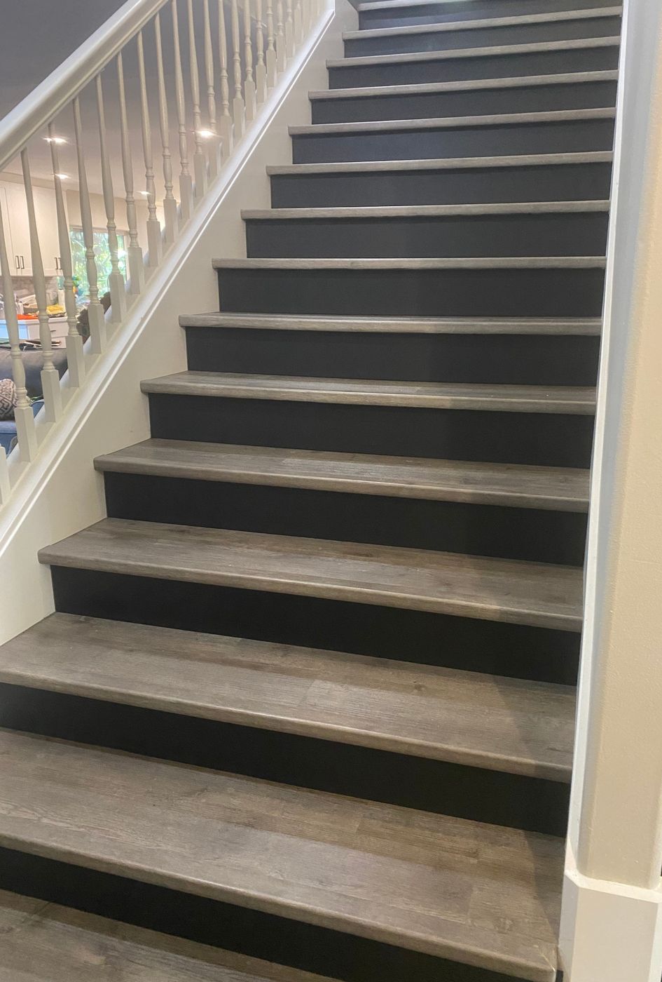 Staircase with gray wood-look treads and black painted risers